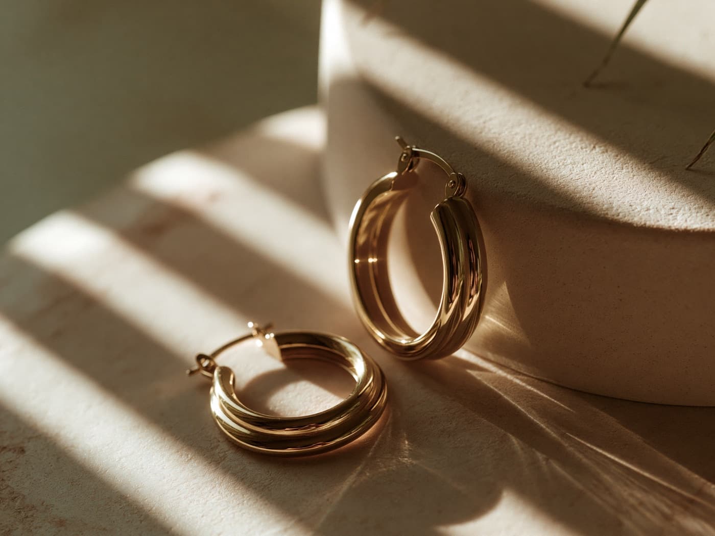 Gold vermeil hoop earrings at 2.5 microns, in warm directional light